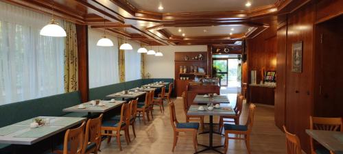 a dining room with long tables and chairs at Hotel Stadt Pasing in Munich