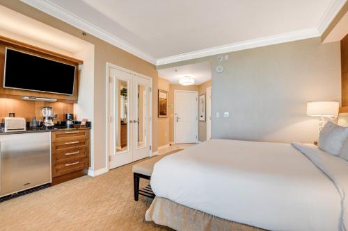 a bedroom with a large white bed and a kitchen at MGM Signature Towers by FantasticStay in Las Vegas