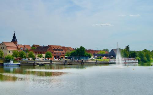 a lake with a fountain in the middle of a town at Das BilderbuchCafe - Ferien - Apartment NO 3 - Markt 7 in Havelberg