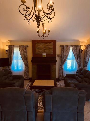 a living room with two couches and a fireplace at Ol-Kine Cottage at The Great Rift Valley Lodge & Golf Resort Naivasha in Naivasha