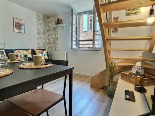 un salon avec une table et un escalier en colimaçon dans l'établissement Les Suites Nature - 2 Logements - Hyper Centre, à Albi