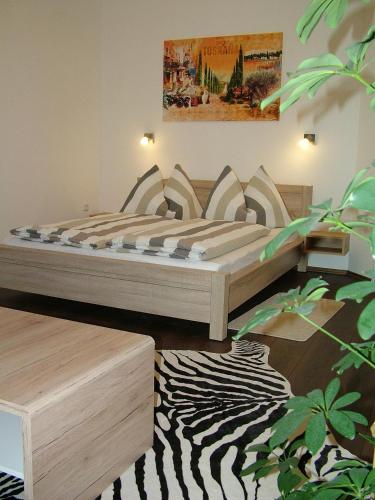 a bedroom with a bed and a zebra print rug at Korzó Apartman in Kőszeg