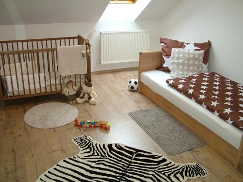 a childs bedroom with a crib and a zebra rug at Korzó Apartman in Kőszeg