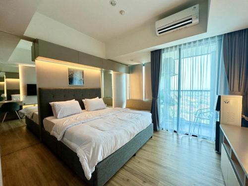 a hotel room with a bed and a large window at Southgate Residence Pasar Minggu with Pool View in Jakarta
