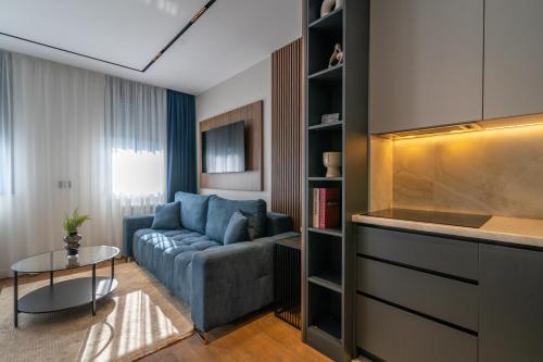 a living room with a blue couch and a table at The Residence 59 in Belgrade