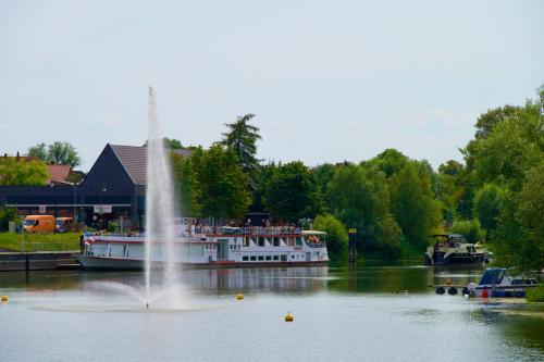 a boat in the water with a fountain at Das BilderbuchCafe - Ferien - Apartment NO 3 - Markt 7 in Havelberg