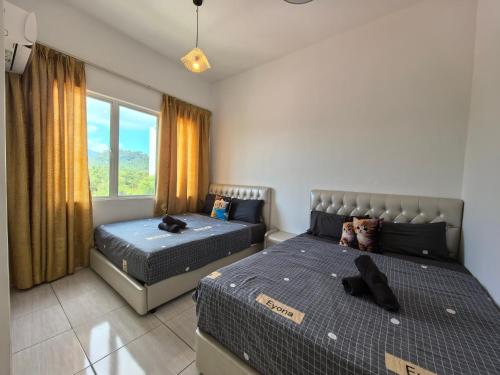 a bedroom with two beds and a window at LANGKAWI JAPANESE STLYE FAMILY DELUXE HOUSE FOR 9Pax New grade in Kuah