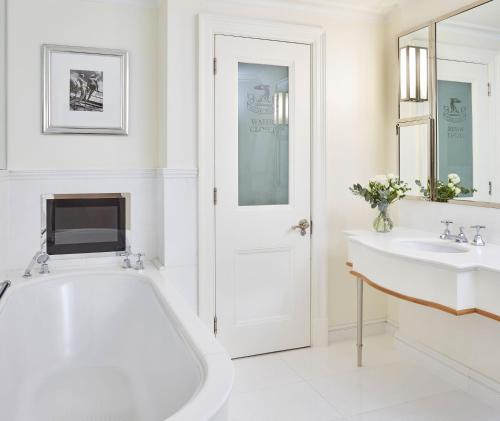 a white bathroom with a tub and a sink at The Connaught, Maybourne in London