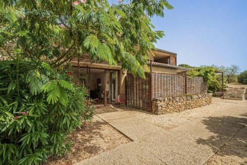 a house with a stone fence and a tree at Louis Henry in Saint-Pierre-des-Champs