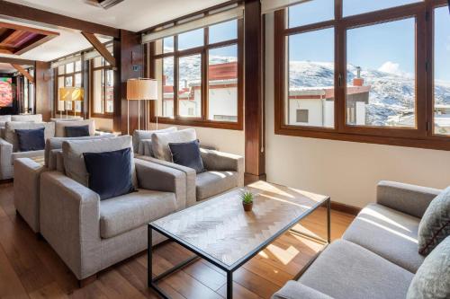 a living room with couches and a table at Melia Sierra Nevada in Sierra Nevada