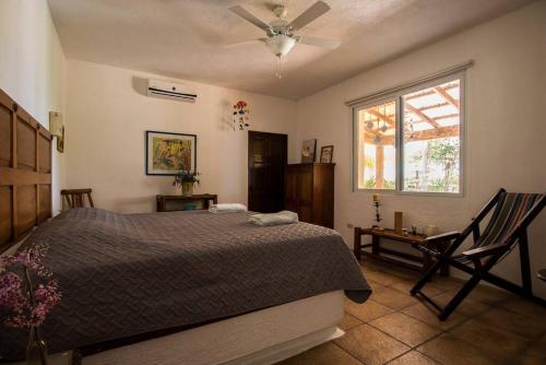a bedroom with a bed and a window and a chair at Monterrico Resort in La Candelaria