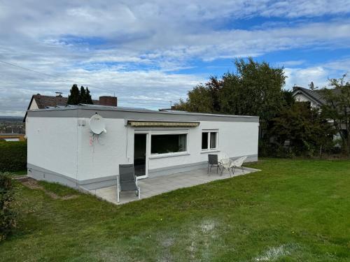 a white house with a deck in a yard at Taunus Paradies in Wehrheim