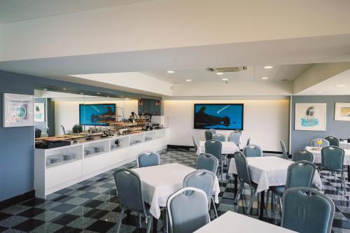a dining room with tables and chairs and a counter at Hotel Avenida in Donostia-San Sebastián