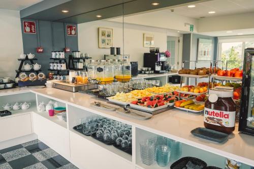 a buffet with fruit and drinks on a counter at Hotel Avenida in Donostia-San Sebastián