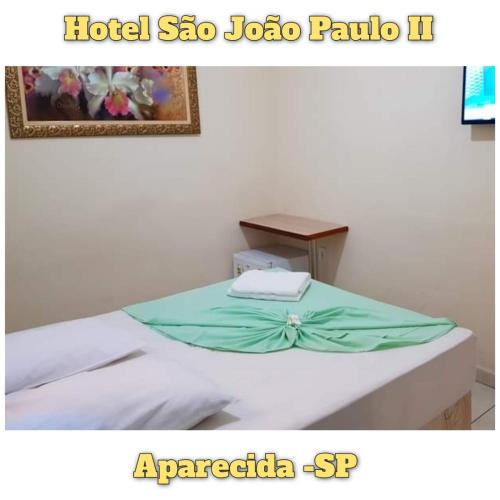 a room with a bed with a towel on it at Hotel São João Paulo II in Aparecida