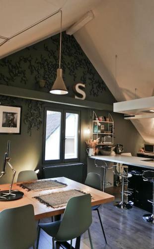 une cuisine avec une table et des chaises dans une pièce dans l'établissement Apartement Strasbourg entre hypercentre et verdure, à Bischheim