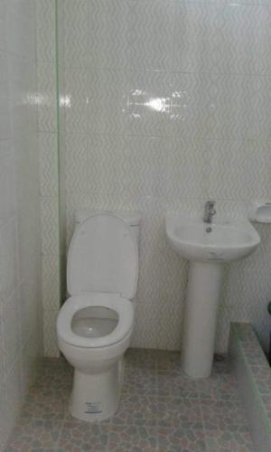 a bathroom with a toilet and a sink at Isla Paraiso Resort-Hotel in Sison