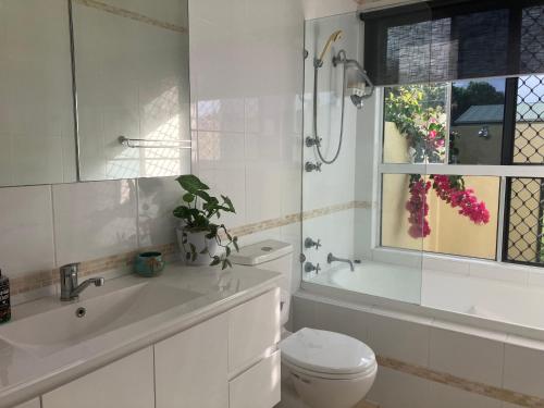 a bathroom with a toilet and a sink and a window at Sunriser in Kurrimine Beach