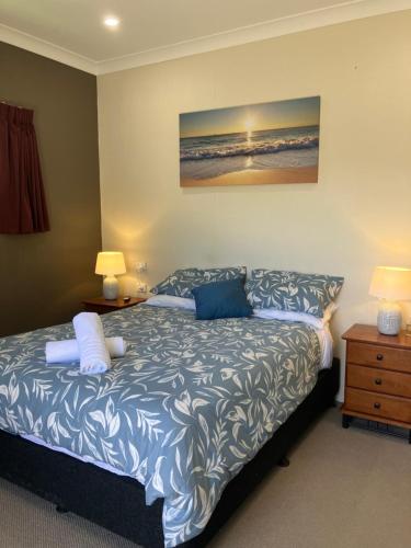 a bedroom with a bed and two night stands and two lamps at Sunriser in Kurrimine Beach
