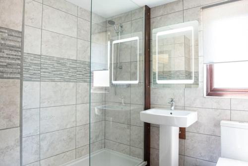 une salle de bain avec un lavabo et une douche en verre dans l'établissement Wild Oats Lodge 3, Yellowtop Country Park, à York