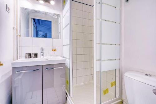 une salle de bain blanche avec une douche et un lavabo dans l'établissement Green apartment Paris city center - V, à Paris