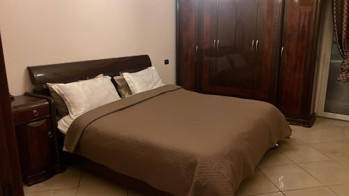 a bedroom with a bed and a wooden cabinet at Veliera Center Apartment in Durrës