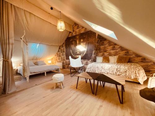 une chambre avec un lit, un canapé et une table dans l'établissement Le Tipi Rouennais, à Rouen