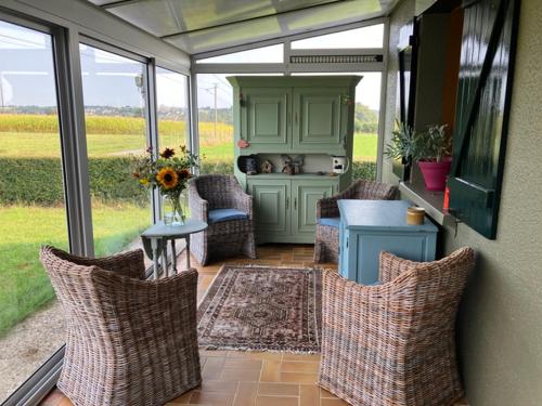 une véranda avec une table et des chaises dans l'établissement Maison à la ferme Grenetemy, à Lavernat