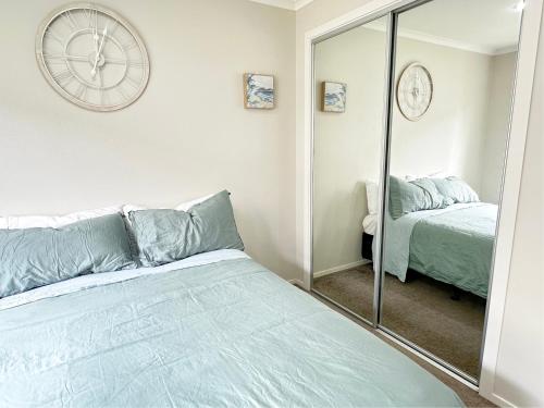 a bedroom with a bed and a clock on the wall at Bright&Cozy Room with attached private bathroom - On street parking only in Auckland