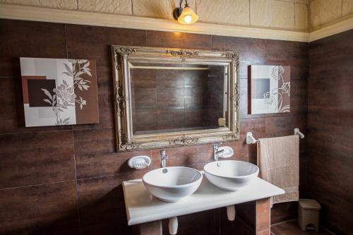 a bathroom with two sinks and a mirror at 3 Bedroom Holiday Farmhouse with Private Pool in Gozo in Żebbuġ