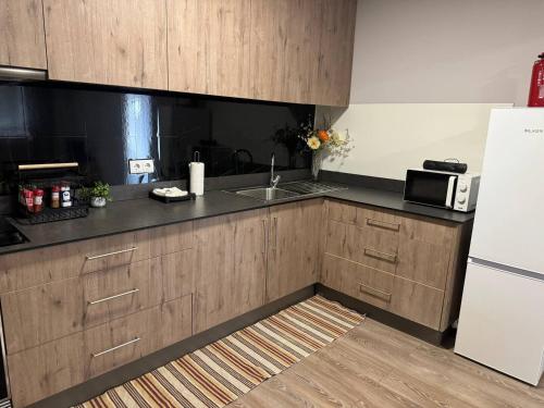a kitchen with wooden cabinets and a sink and a refrigerator at Meu Refugio Apartamento in Silveira