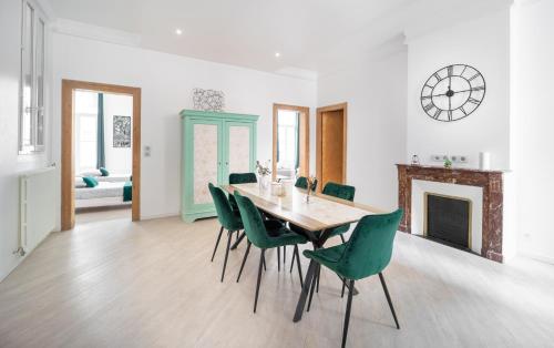 une salle à manger avec une table et des chaises vertes dans l'établissement L'émeraude - Centre, Spacieux & Tout équipé, à Montpellier