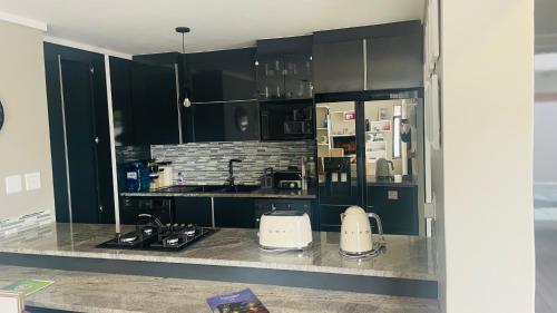 Una cocina con gabinetes negros y encimera. en Roloma Property, en East London