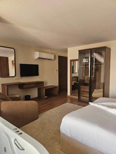 a hotel room with a bed and a television at The Home Boutique Hotel Pyramids Inn in Cairo