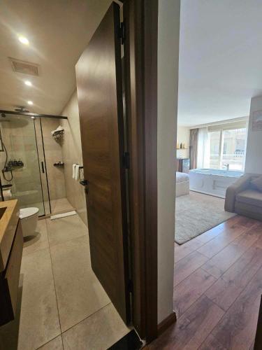 a bathroom with a shower and a toilet and a glass door at The Home Boutique Hotel Pyramids Inn in Cairo