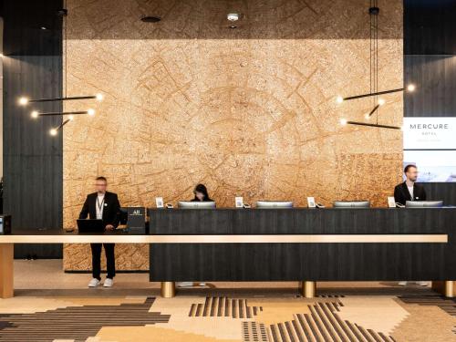 a group of people sitting at a reception desk at Mercure Szczyrk Resort in Szczyrk
