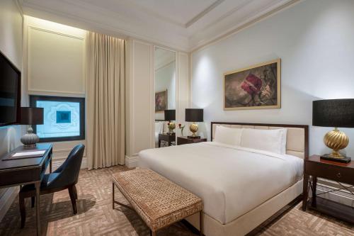 a bedroom with a large white bed and a desk at The Hotel Galleria Jeddah, Curio Collection by Hilton in Jeddah