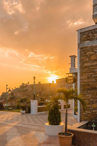 a building with a sunset in the background at Clarks Resort The Archi`s Castle, Ajmer in Ajmer