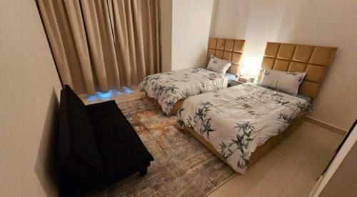 a bedroom with two beds and a table and a window at Splendid Villa Rooms near Dubai Airport in Dubai