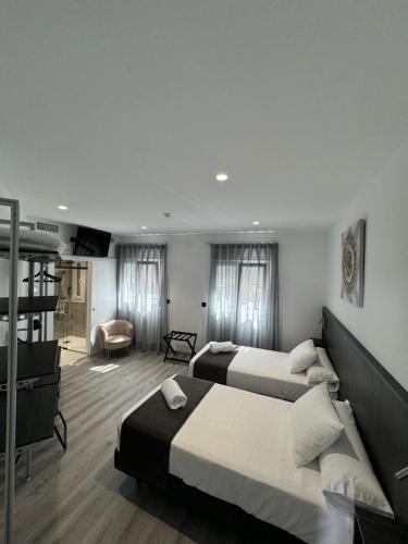 a bedroom with two beds and a living room at VillaRoygar in Guareña