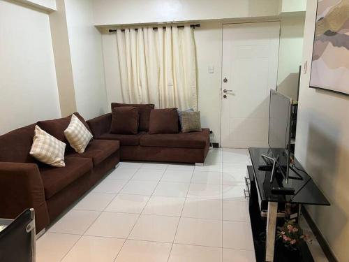 a living room with a couch and a table at Zinnia North Tower 3202 in Manila