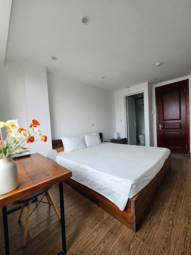a bedroom with a large bed and a wooden table at Lakeside House Hanoi in Hanoi