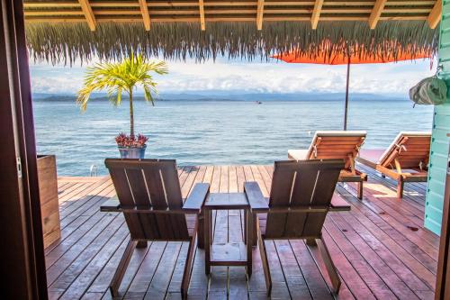a patio with a table and chairs and the ocean at Sol Bungalows Bocas del Toro in Bocas del Toro