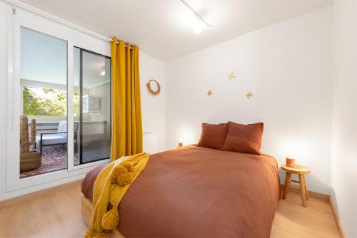 une chambre avec un grand lit et une fenêtre dans l'établissement T2 Calme absolu - Coeur Toulouse - Saint Cyprien - climatisation - Terrasse arborée, à Toulouse