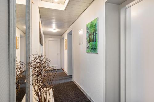 a hallway with white walls and a plant at Schönes Zimmer mit eigenem Bad in Albstadt