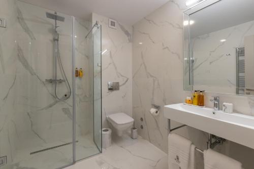 a bathroom with a shower and a toilet and a sink at Reea Boutique Hotel in Târgovişte