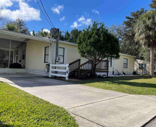 a house with a porch and a tree in front of it at ChassRiverVibes in Homosassa