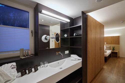 a bathroom with a sink and a mirror at m3Hotel in Sankt Anton am Arlberg