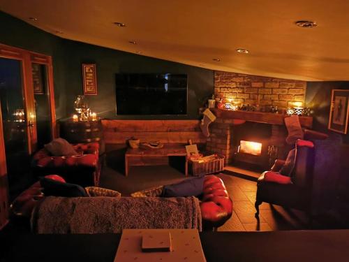 a living room with couches and a fire place at Cottage incredible views off grid private dog friendly garden cosy in Holmfirth