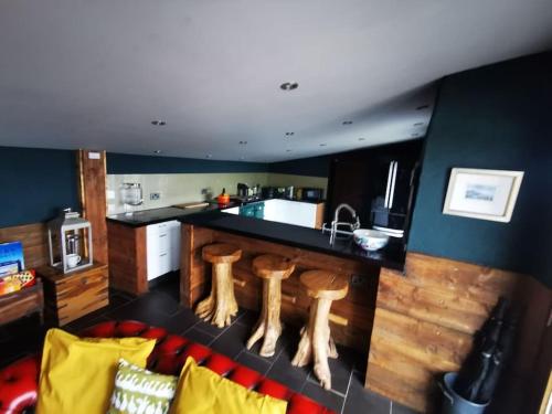 a kitchen with a bar with wooden stools in it at Cottage incredible views off grid private dog friendly garden cosy in Holmfirth